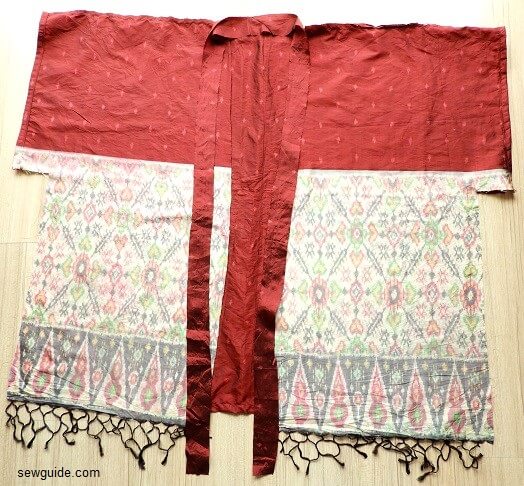 A slong piece of fabric cut to bind the neckline and front of the kimono sleeved cardigan