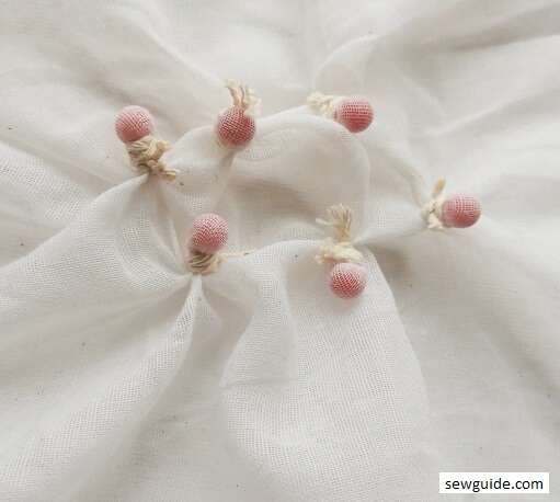 Fabric tied around beads for knot tie-dye patterns